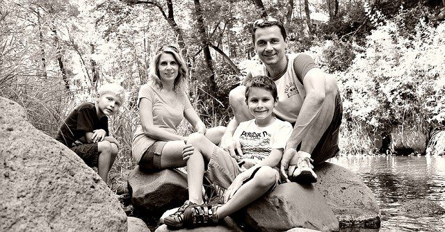 black and white photo of a family posing in the woods